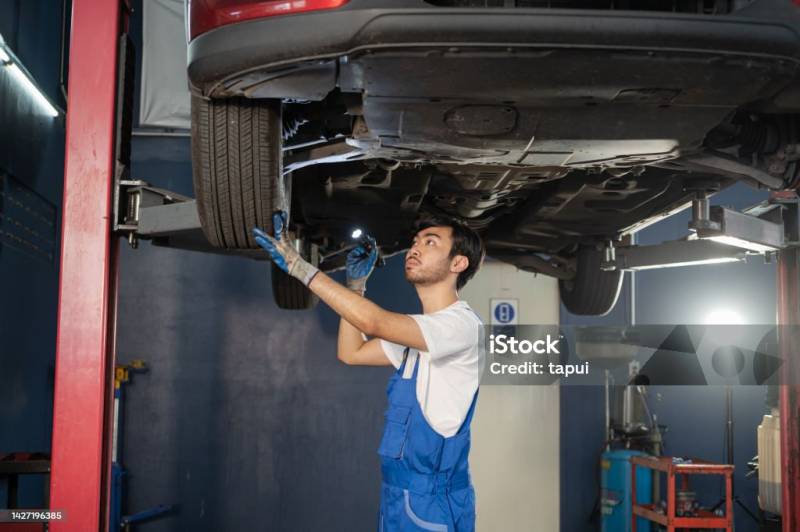 Équipe professionnelle inspectant les freins pendant le contrôle technique