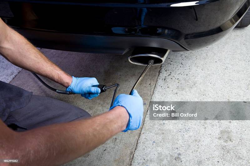 Expert vérifiant les émissions de voiture lors du contrôle technique à Istres